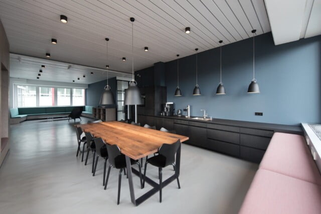 Photo d'une salle à manger ouverte décorée en style industriel avec une table en bois, une banquette rose, une banquette verte et des murs bleus.